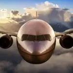 Airplane flying above the clouds during colorful sunset or sunrise. Concept of Travel